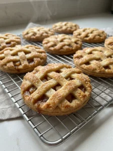A stack of several apple pie cookies, showing the flaky crust and apple filling.