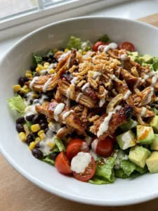 Four bowls of colorful BBQ chicken salad ready to be served for dinner.