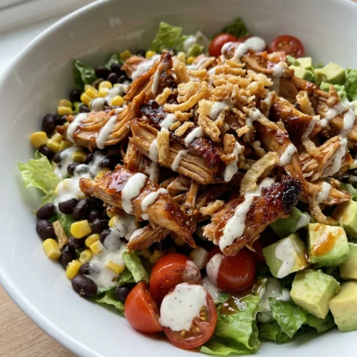 Four bowls of colorful BBQ chicken salad ready to be served for dinner.